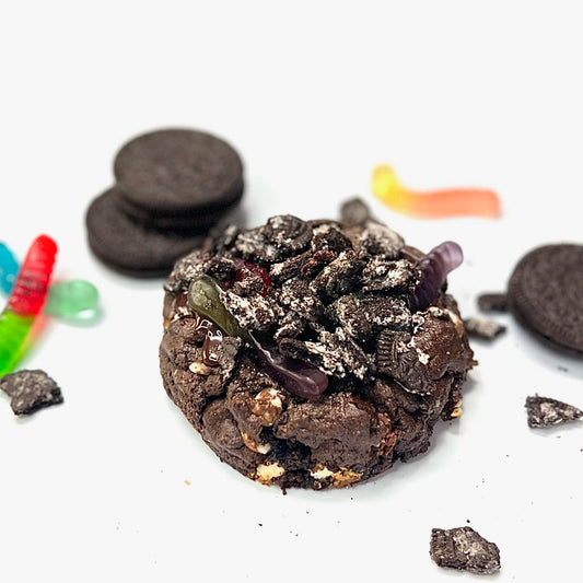 A chocolate cookie with vanilla cream, Oreo topping, and gummy worms.